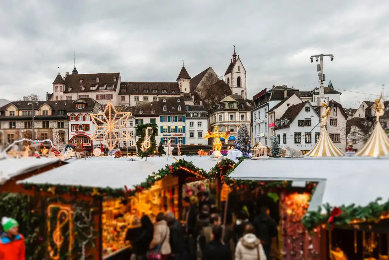 Pessoas passeando pelo Mercado de Natal de Zurique, na Suíça, entre barracas de doces e artesanatos tradicionais