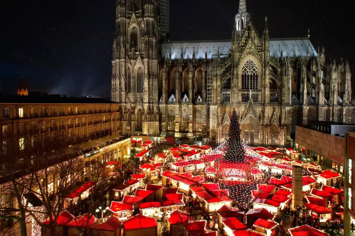 Árvore de Natal e barracas iluminadas à noite no Mercado de Natal em frente à Catedral de Colônia, na Alemanha
