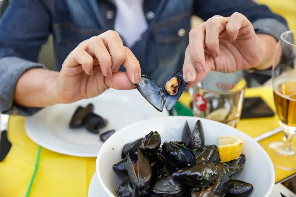 Viajante degusta mariscos no litoral da Sicília, um segredo da longevidade