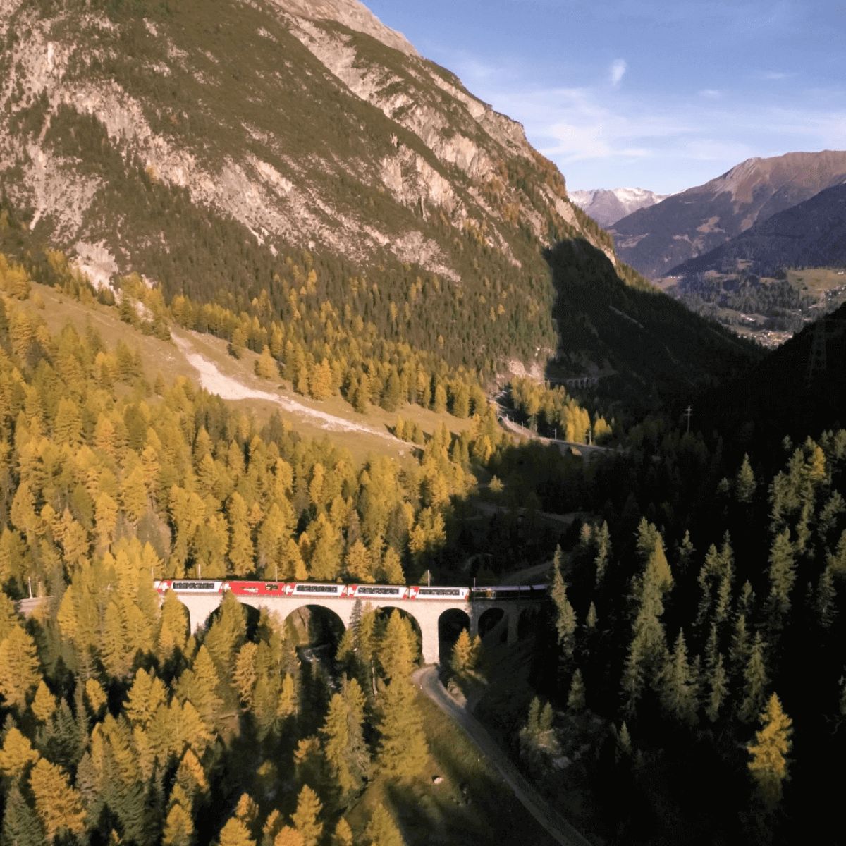 Viagem em um dos trens panorâmicos na Suíça, com vista para os Alpes e as paisagens douradas do outono