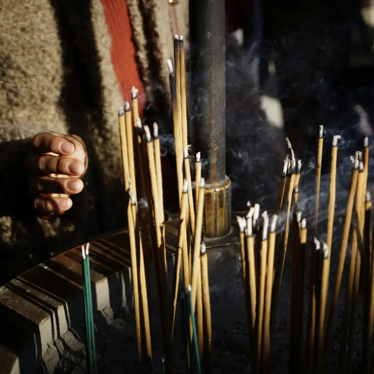 Chinês acende incenso em um altar em homanagem a seus antepassados