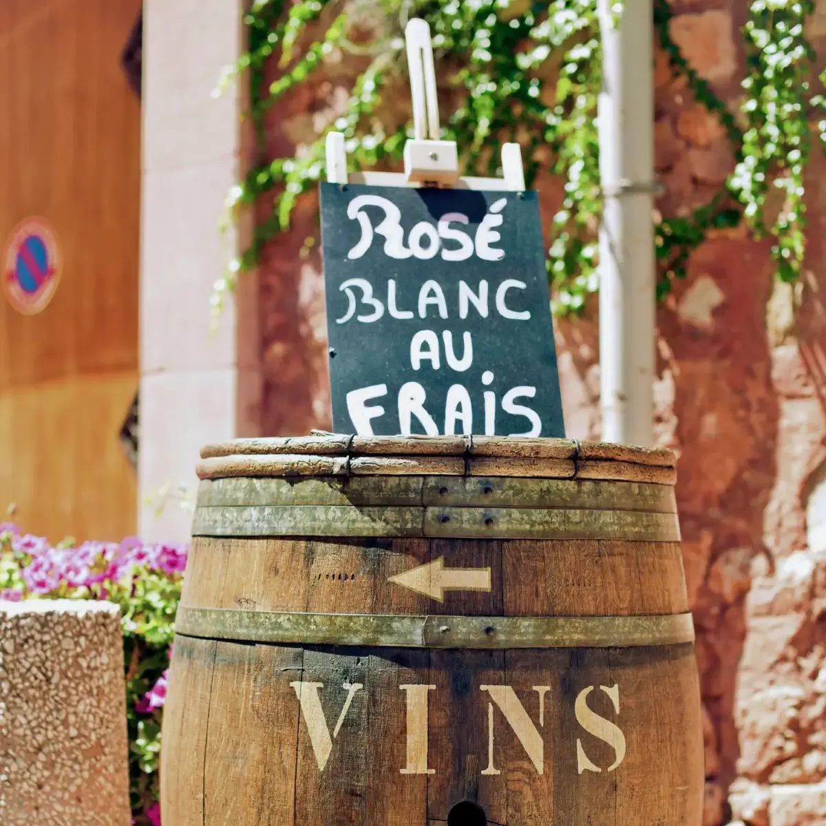 Barril de vinho francês em uma cidade turística da Provence, no sul da França, cercado por flores e vegetação.