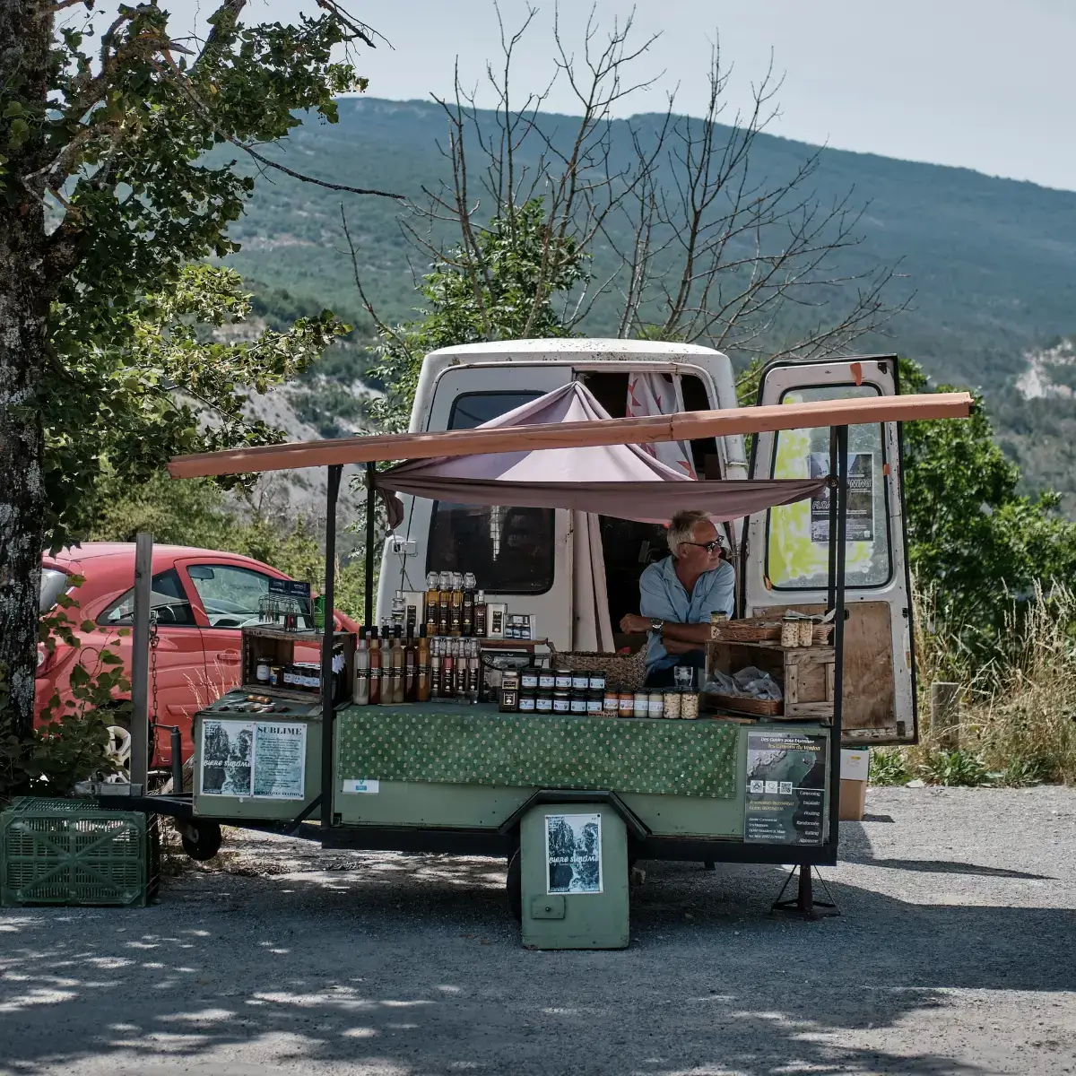 Vendedor de geleias e outros produtos artesanais típicos da Provence, sul da França, sentado em seu carrinho.