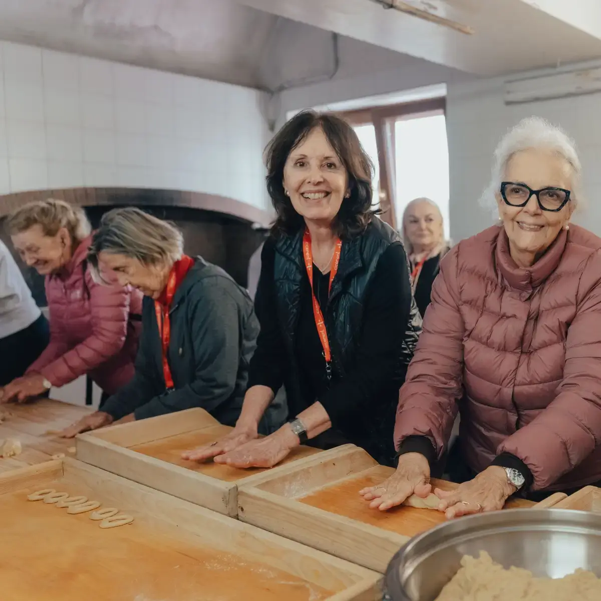 Viajantes da terceira idade vivendo uma experiência gastronômica na Puglia, Itália, fazendo massa fresca