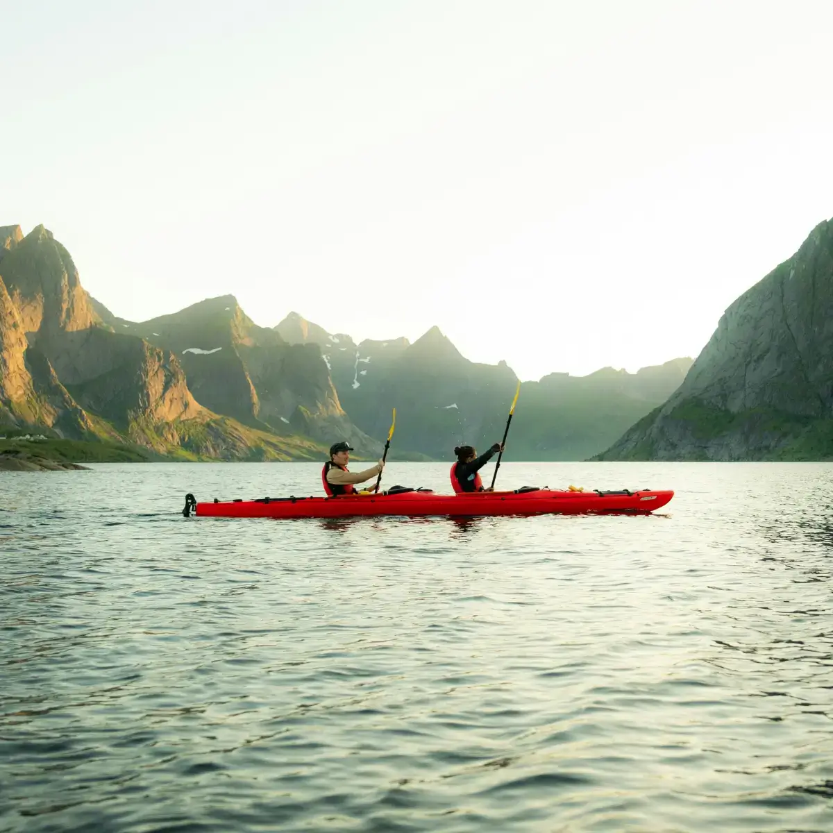 Noruegueses remando em um caiaque pelos fiordes, aproveitando a vida ao ar livre nas Ilhas Lofoten